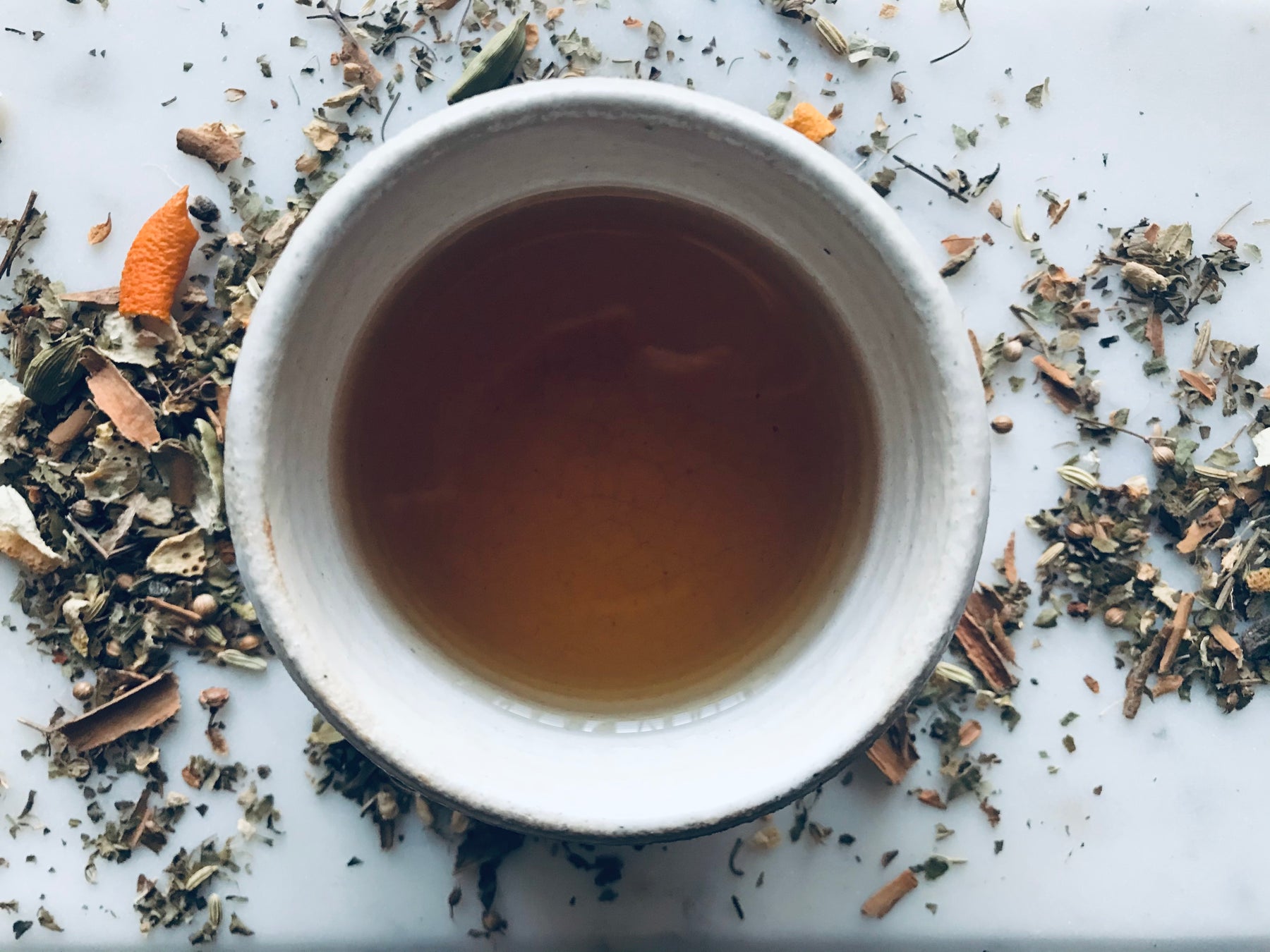 cup of tea with herbs around