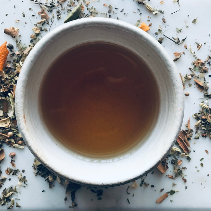 cup of tea with herbs around